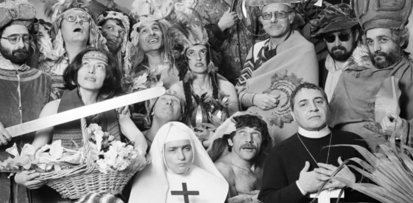 La Conquista, registro de quienes participaron de la muestra del Rojas en 1992. Liliana Maresca, de monja; las indiecitas Elba Bairon (vincha de tela) y Marcia (vincha de plumas). El Búlgaro mira al cielo, junto a la monja. Asoma por la derecha con gorro, Eduardo Stupía. La sesión fue fotografiada por Res y Marcos López.