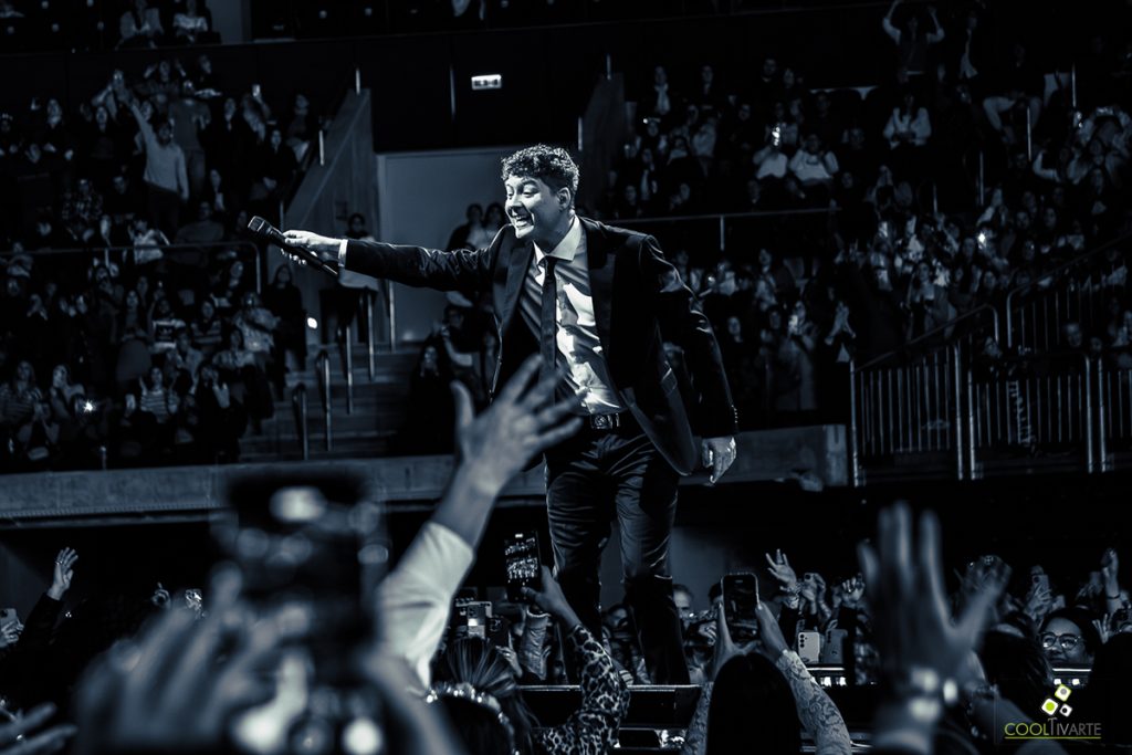 artista en el escenario rodeado de públio