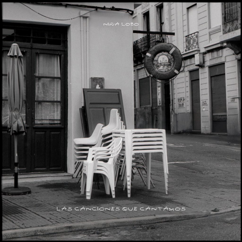 esquina de calle con sillas blancas apiladas