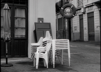 esquina de calle con sillas blancas apiladas