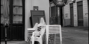 esquina de calle con sillas blancas apiladas